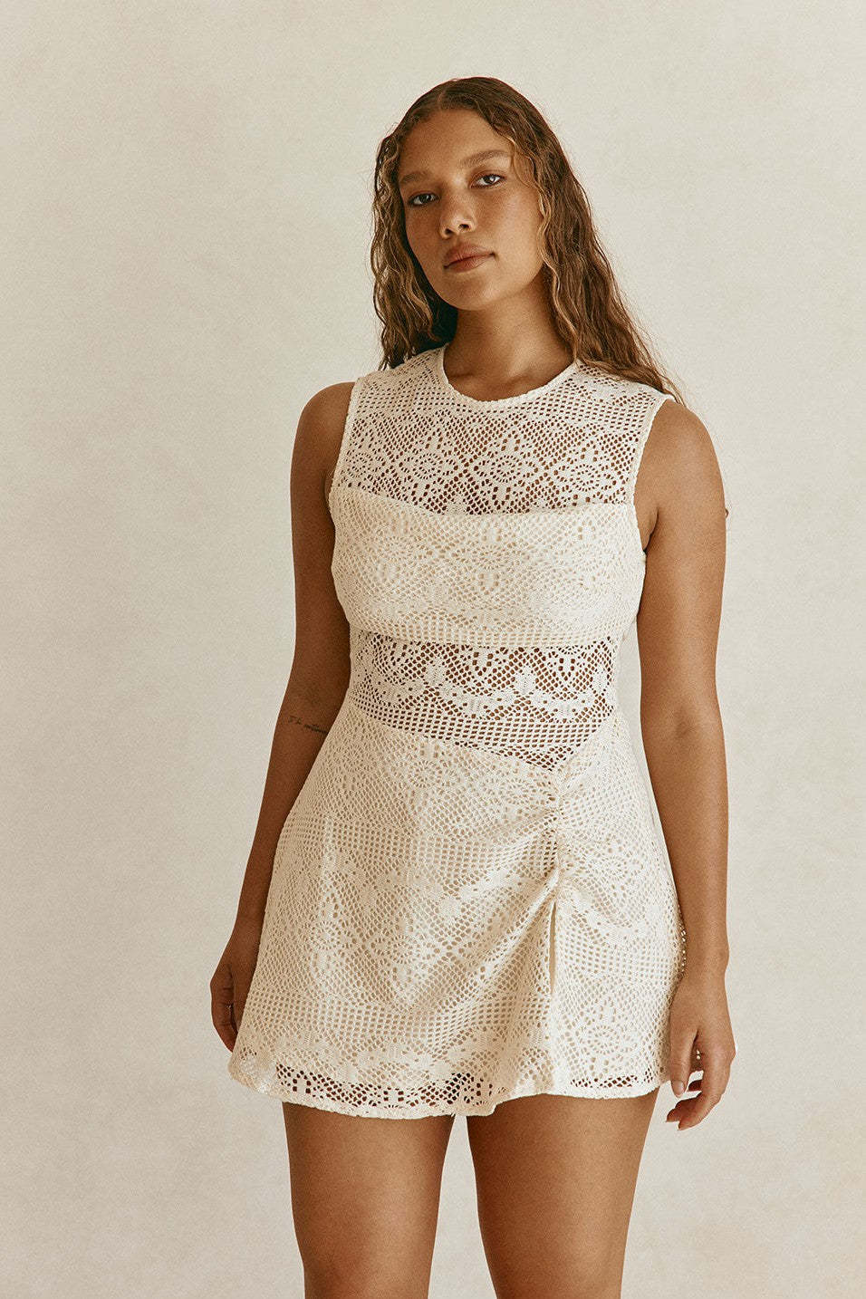 Beige mini dress with an A-line skirt, styled on model