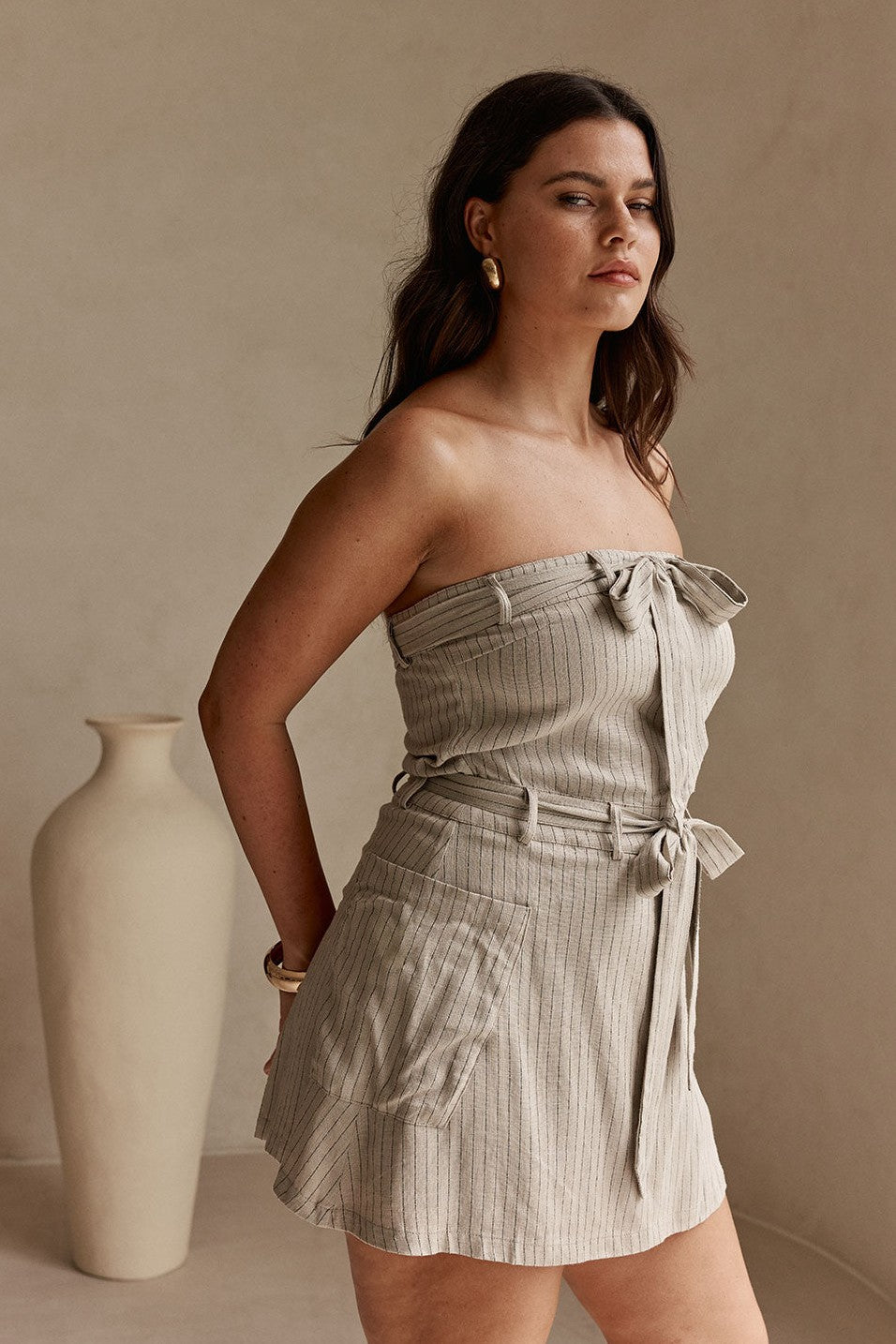 Grey mini dress with a strapless neckline, styled on model
