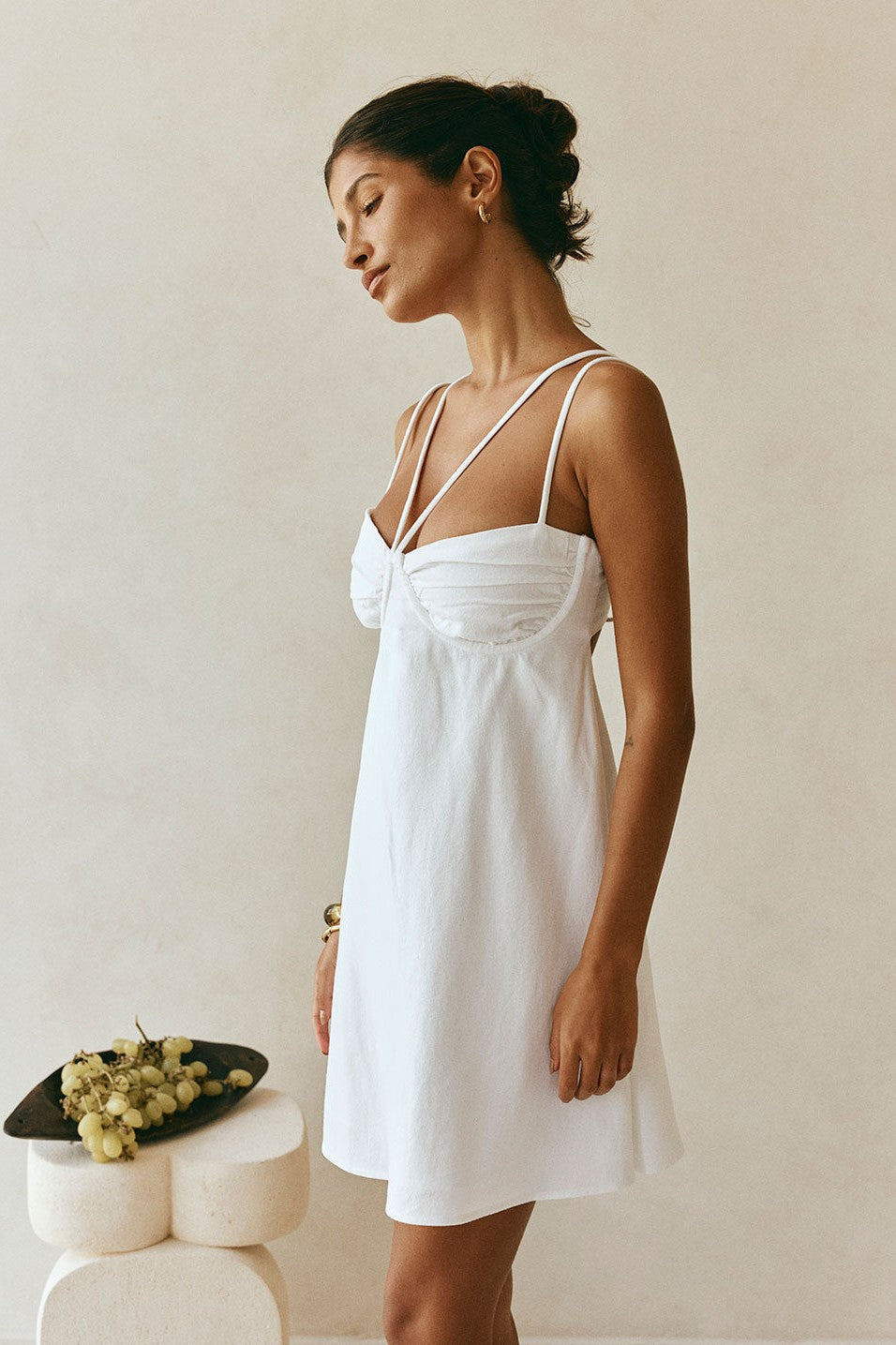 White mini dress with a round neckline, detail view
