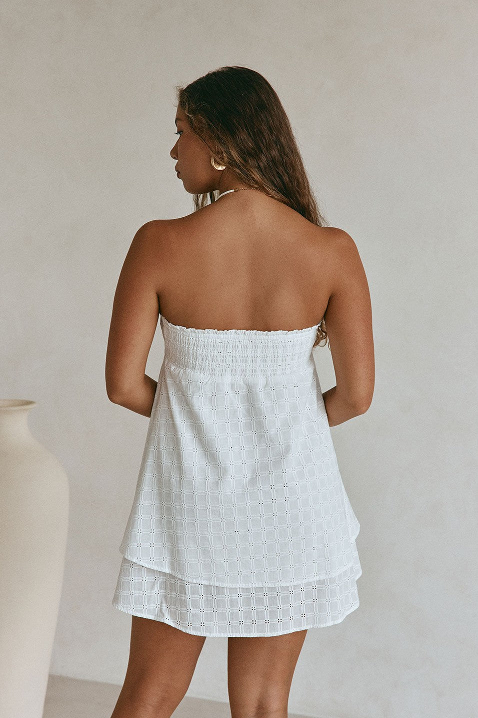 White mini dress with a strapless neckline, back view