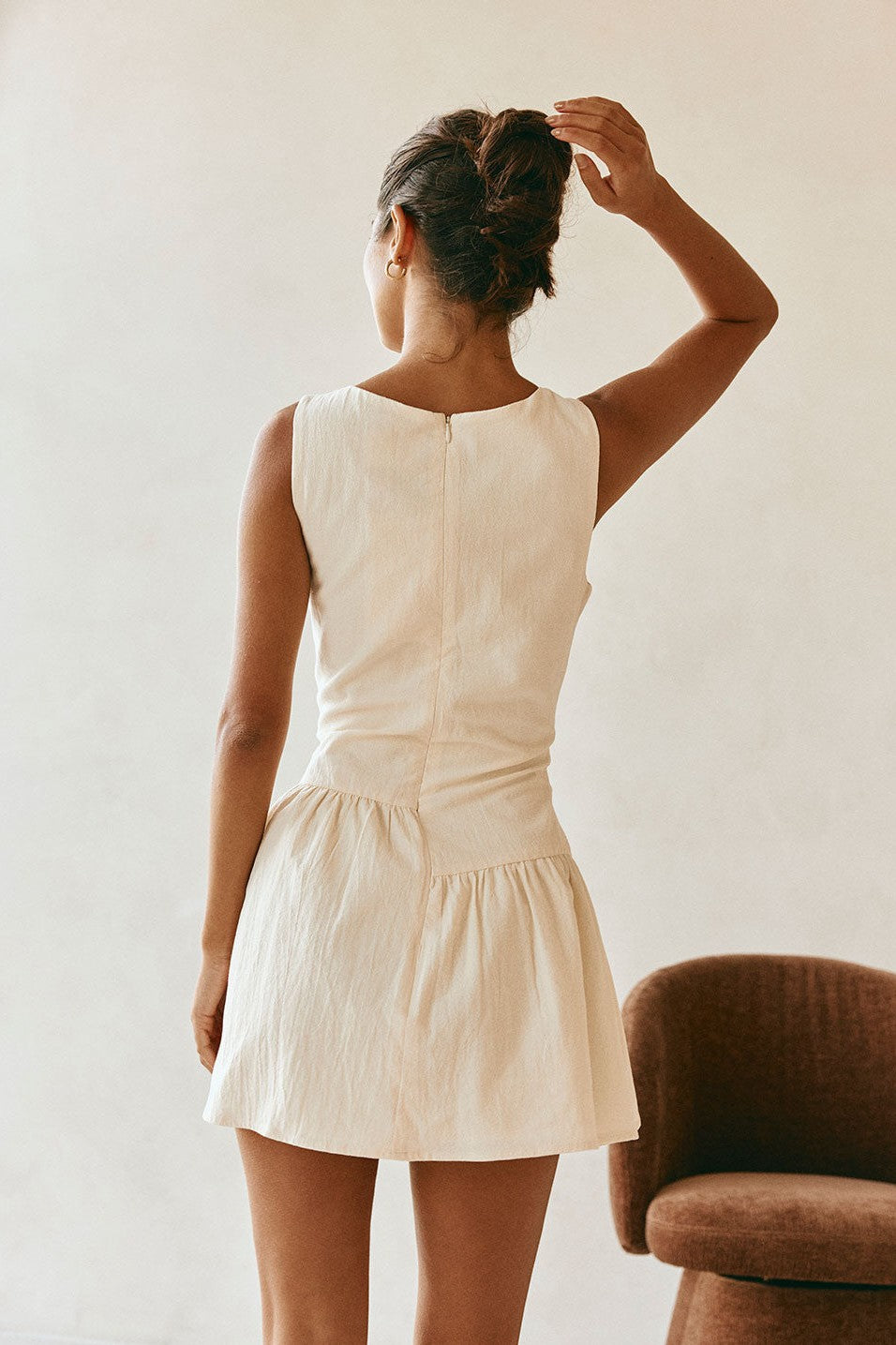 Cream mini dress with a boat neckline, styled on model