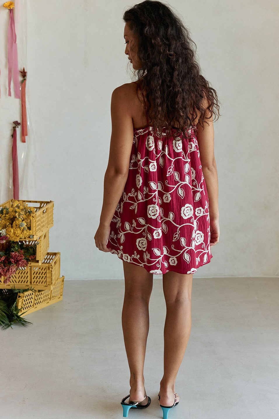 Red mini dress with slim tie straps, styled on model