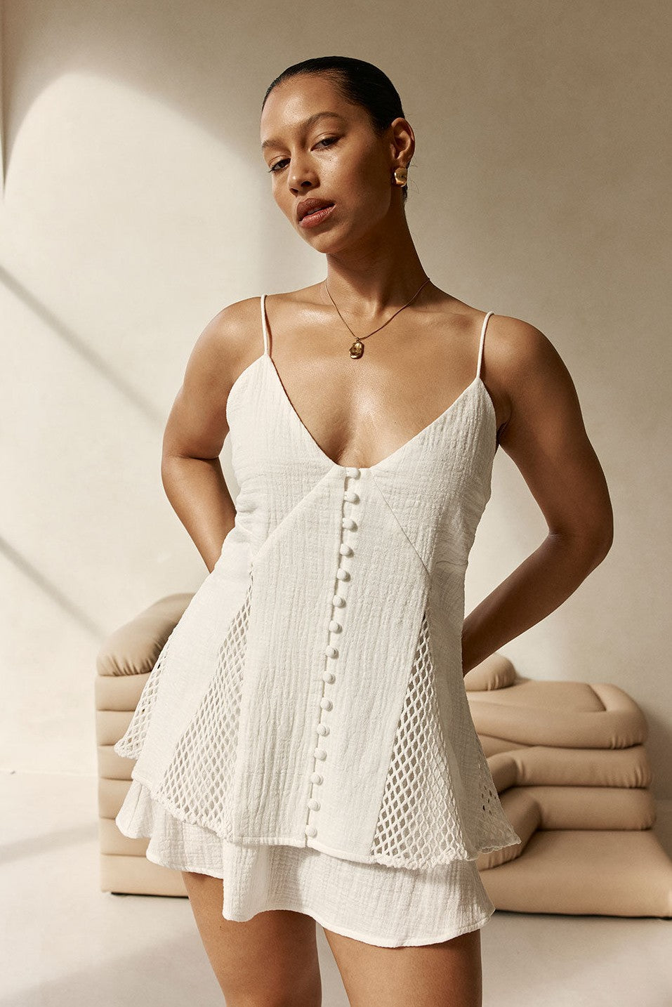 White mini dress with an A-line skirt, styled on model